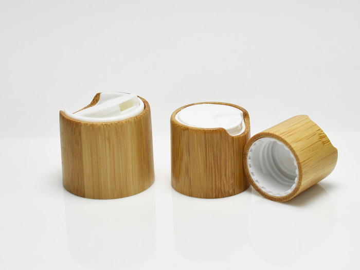 A stylish and sustainable bamboo disc top cap designed for dispensing liquids, perfect for eco-conscious cosmetic and personal care bottles.
