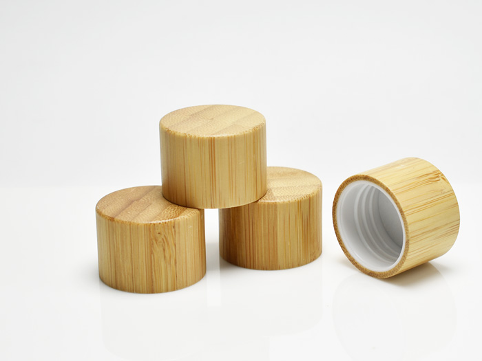 A bamboo bottle cap featuring a sleek design with a durable plastic inner seal, blending natural aesthetics with reliable functionality for cosmetic and personal care packaging