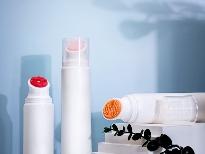 Cosmetic tube with silicone massage brush applicator for face and body wash. Features soft bristles for gentle application. Customizable and available for wholesale.